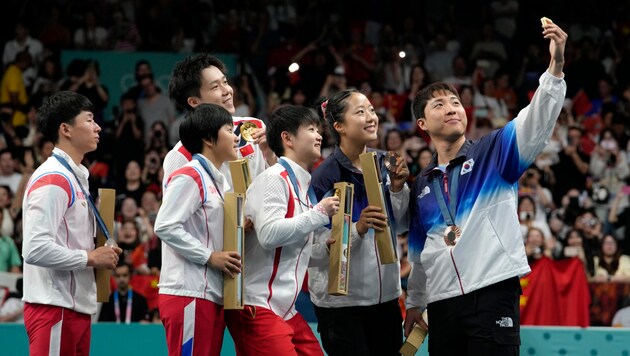 Lim Jonghoon (right) poses with opponents from North Korea and China. (Bild: AP ( via APA) Austria Presse Agentur/ASSOCIATED PRESS)