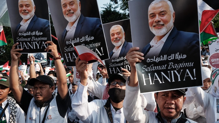 Demonstranten halten Porträts des verstorbenen palästinensischen Hamas-Führers Ismail Haniyeh mit der Aufschrift „Herzlichen Glückwunsch zu deinem Märtyrertod“ während einer pro-palästinensischen Demonstration vor der US-Botschaft in Jakarta.