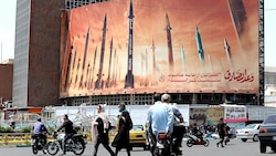 Ein Plakat mit iranischen Raketen in Teheran als Drohgebärde gegenüber Israel (Bild: APA/AFP/ATTA KENARE)