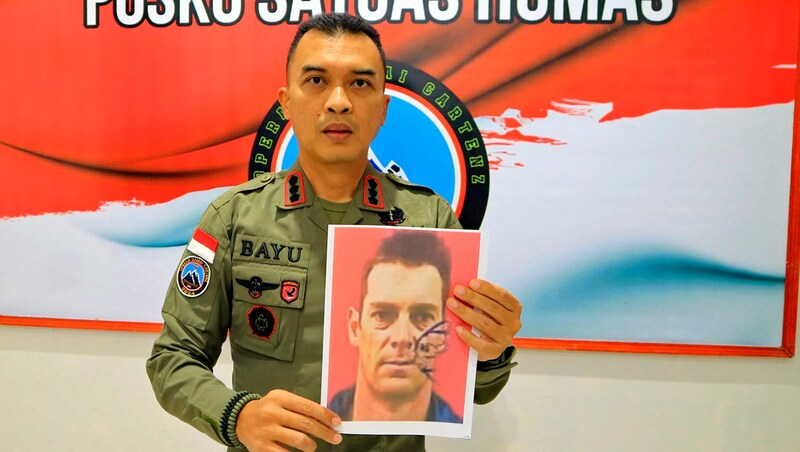 An army spokesman with a portrait of the slain pilot Glen Malcolm Conning (Bild: AP/Indonesian Police)