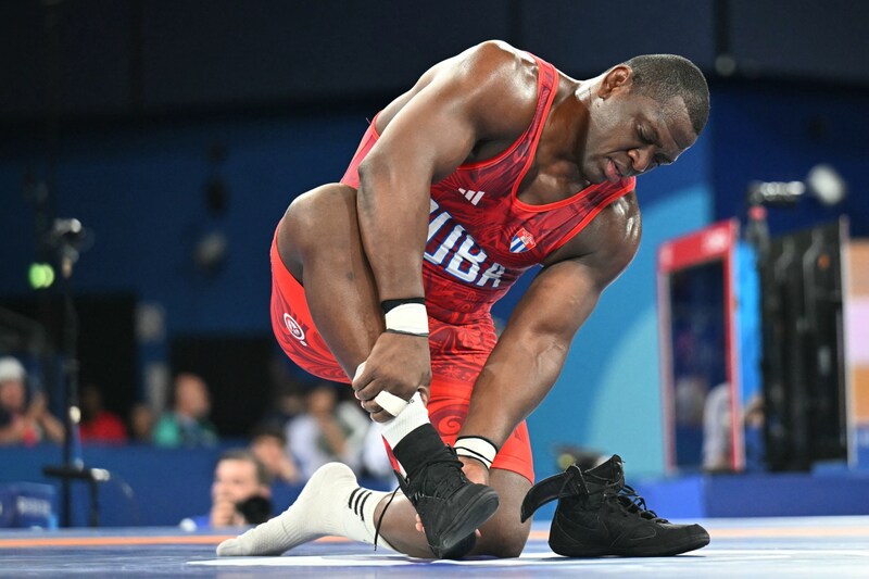 Mijain Lopez takes off his shoes, symbolically ending his career. (Bild: AFP/APA/Punit PARANJPE)