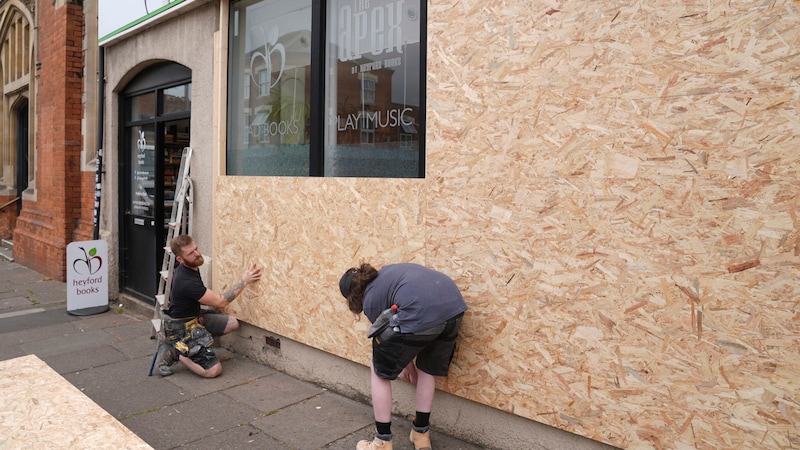 Ein Pub-Besitzer verbarrikadiert aus Angst vor einer neuen Krawall-Nacht in North Finchley, London, seine Fenster. (Bild: AP/PA)