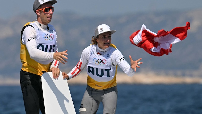 Lukas Mähr and Lara Vadlau celebrate their triumph with a red-white-red flag. (Bild: AFP/APA/NICOLAS TUCAT)