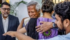 Mohammad Yunus wird von einer Anhängerin geherzt. (Bild: APA/AFP/Luis TATO)