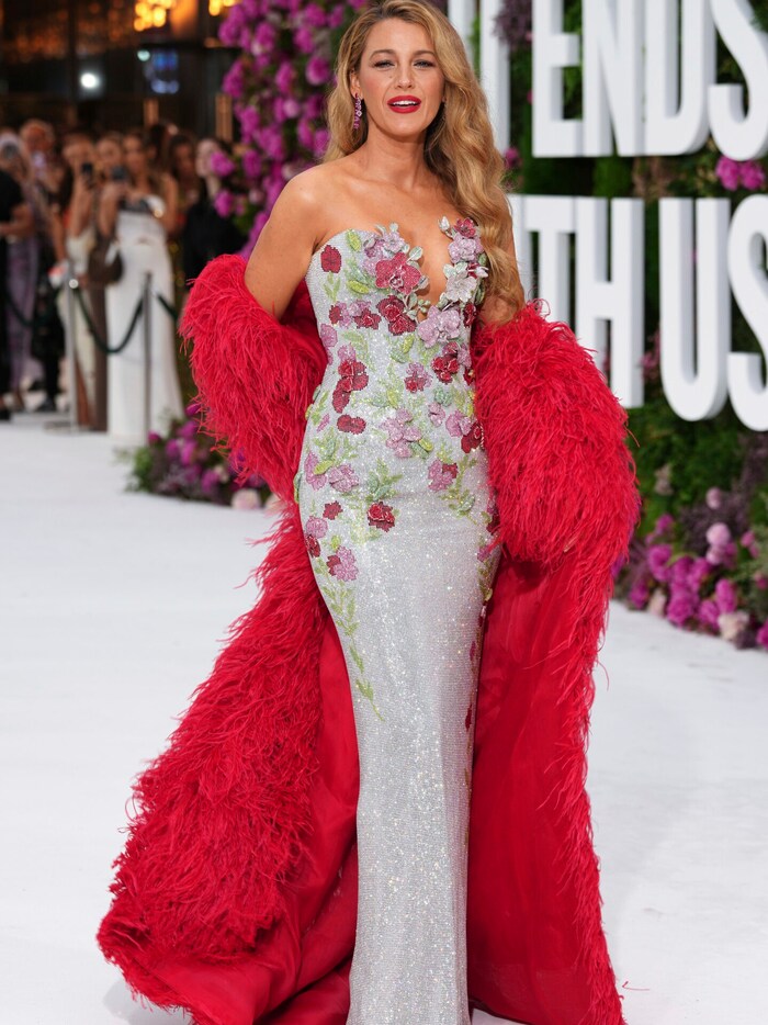 The actress paired the glittering dress with a red feather coat.
