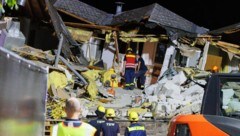 Feuerwehrleute und Einsatzkräfte des Technischen Hilfwerks räumen Trümmer beiseite, um an den letzten noch verschütteten Toten zu gelangen. (Bild: APA/dpa/Lando Hass)