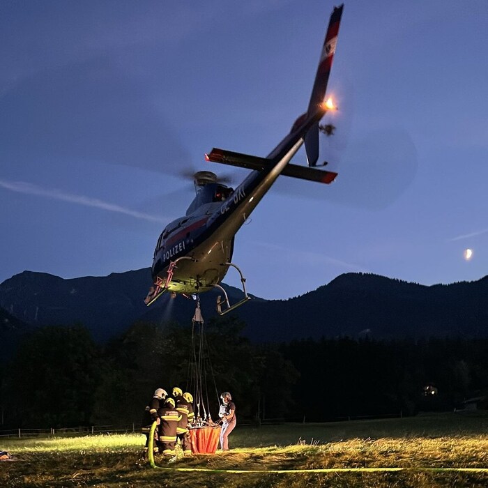 Das Löschwasser wie auch die Einsatzkräfte selbst werden per Hubschrauber zum Brandort ...