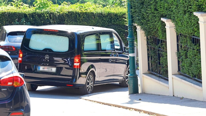 Der Wagen eines Bestattungsunternehmens bei der Zufahrt zum Lugner-Anwesen