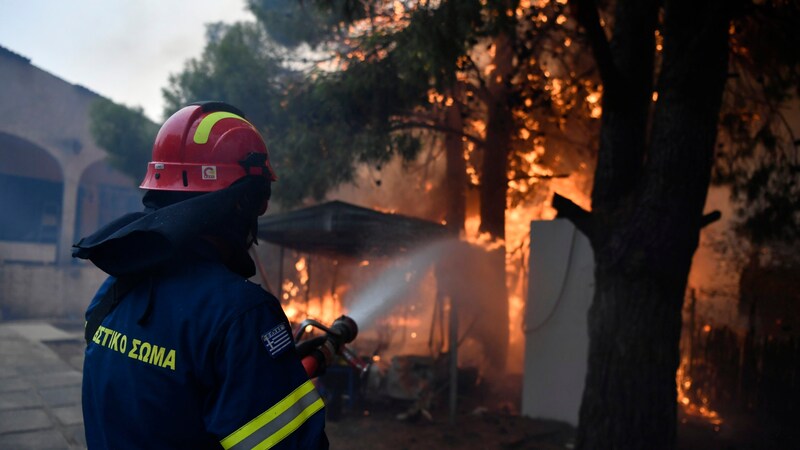 Ein Feuerwehrmann im Kampf gegen die Flammen (Bild: APA/Associated Press)