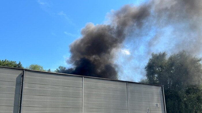 Dunkler Rauch stieg von dem Flachdach des Gebäudes auf. Durch die hohen Temperaturen des Feuers zersprang bei den dortigen PV-Paneelen das Glas. 