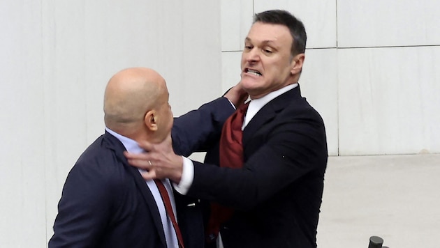 Alpay Ozalan (right) slapped Ahmet Sik during his speech - a brawl ensued. (Bild: AFP/APA/Adem ALTAN)