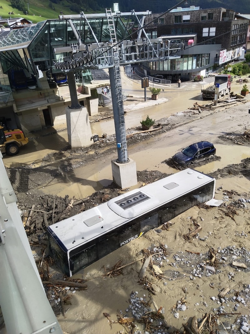 Trail of devastation in St. Anton. Here a Postbus, half of which is covered in mud and debris. (Bild: Peter Freiberger)