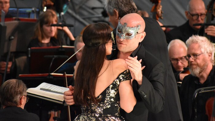 Forbidden love behind masks: Gustavo (Michael Fabiano) and his beloved Amelia (Joyce El-Khoury). ...
