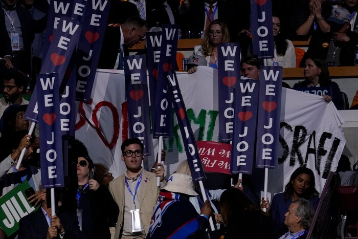 Delegates block the view of a pro-Palestine banner.