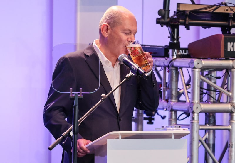 Drinking to forget? Scholz during his speech at the Stoppelmarkt. (Bild: AFP/FOCKE STRANGMANN)