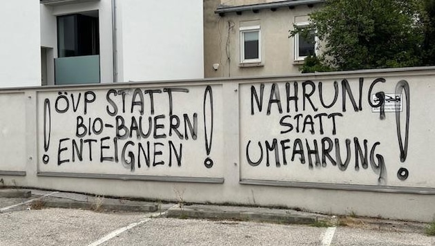 Parolen gegen die Wiener Neustädter Ostumfahrung und die Enteignung der Bauern für das Straßenbauprojekt „zieren“ jetzt einen Privatparkplatz in den Innenstadt.  (Bild: Günter Tschank)