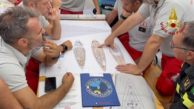 Mit einem Plan des Schiffes versuchen die Einsatzkräfte, die vermissten Personen im Schiffsinneren zu finden. (Bild: AFP)