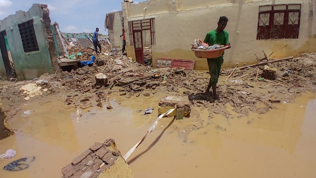 After heavy flooding, people move their belongings to safety. (Bild: APA/AFP)