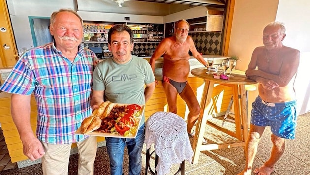 Mustafa Tas (2nd from left) serves kebab plates to guests and Mayor Edi Zach in the Heiligenkreuz Badkantine. (Bild: Christian Schulter)