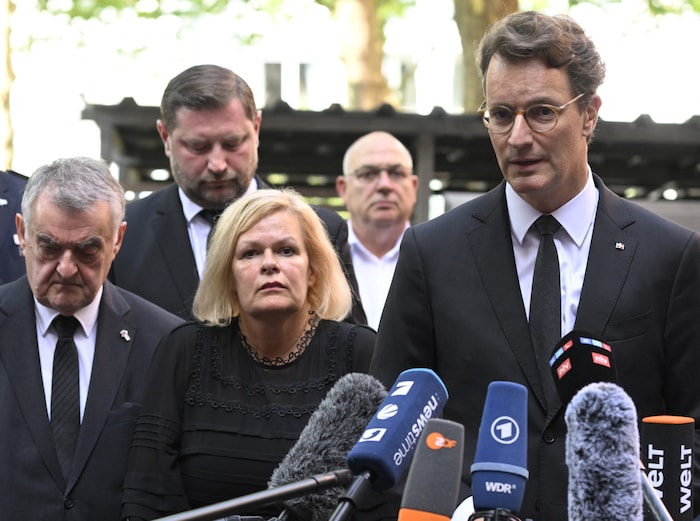 NRW-Ministerpräsident Hendrik Wüst (re.), die deutsche Innenministerin Nancy Faeser, NRW-Innenminister Herbert Reul (li.) und Oberbürgermeister Tim Kurzbach (hinten) bei einem Pressestatement am Samstag in Solingen