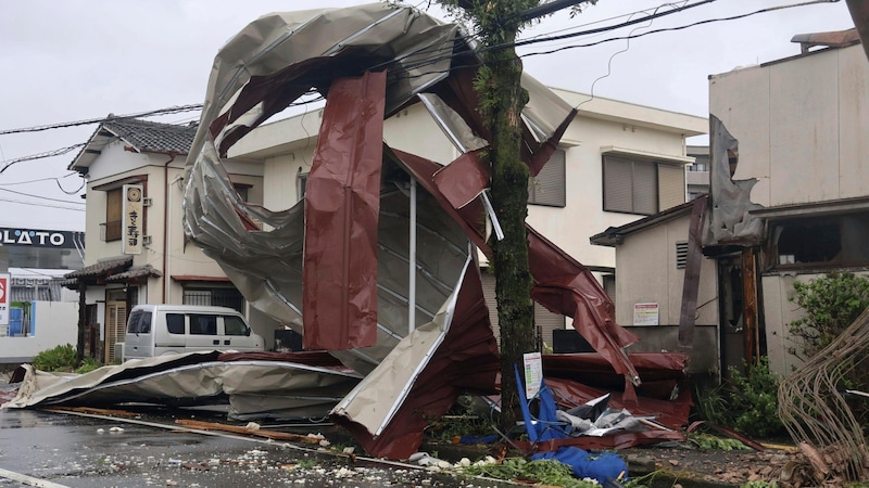 In Miyazaki, Westjapan, ist wegen der starken Winde sogar ein schwerer Metallgegenstand in einer Stromleitung hängen geblieben. (Bild: ASSOCIATED PRESS)