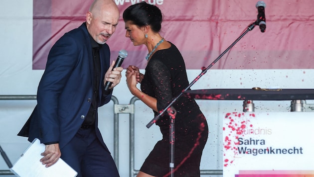 Sarah Wagenknecht was hit in the face, neck and dress by the paint. She was on stage with BSW candidate Steffen Quasebarth. (Bild: APA/AFP)