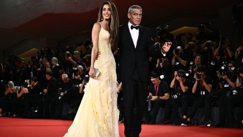 Amal Clooney stahl ihrem Ehemann George Clooney im zitronengelben Kleid (fast) die Show. (Bild: APA/AFP/Marco BERTORELLO)