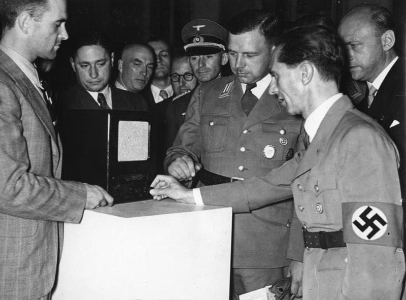 Hitlers Propagandaminister Joseph Goebbels lässt sich auf der Funkausstellung 1938 einen Volksempfänger vom Typ VE 301 Dyn vorführen. Im Volksmund nannte man das Propaganda-Radio „Goebbels Schnauze“. (Bild: Bundesarchiv, Bild 183-H10252 / Autor/-in unbekannt / CC-BY-SA 3.0)