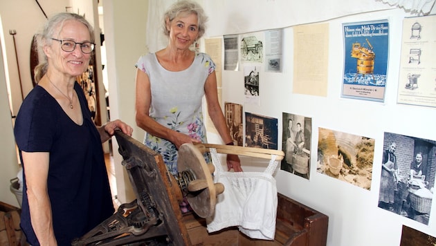 Jutta Mangold-Poscharnigg (left) and Eva Hojnik with a wooden washing machine with pulsator from 1860 - a revolution at the time! (Bild: Fürbass Josef/Josef Fürbass)