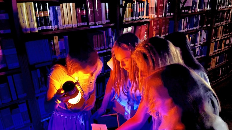 In the completely darkened library in Parliament, the students first had to grope in the dark to find various clues to get to the reading room, where the final puzzle was revealed in the light of a floor lamp. (Bild: Christoph Engelmaier)