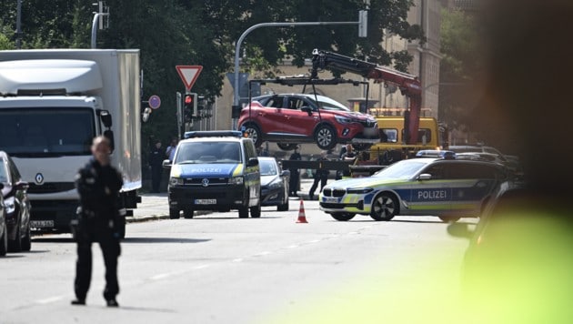 Das Auto des Schützen mit Salzburger Kennzeichen wird in der Münchner Innenstadt abgeschleppt. (Bild: AFP/LUKAS BARTH-TUTTAS)