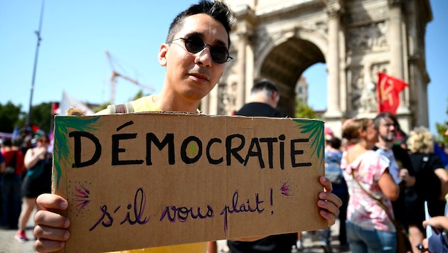 Dieser Demonstrant in Marseille fordert ganz höflich „Demokratie“. (Bild: APA/AFP/Christophe SIMON)