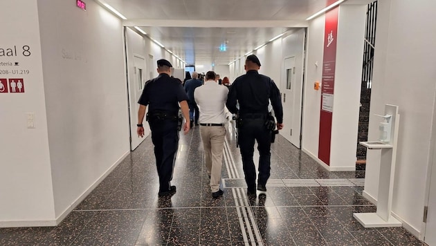 I hope nobody sees me: The defendant had the handcuffs pressed close to his face during the presentation. (Bild: Harald Schume)