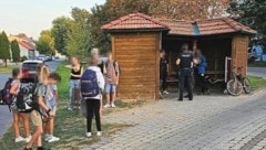 Drei Migranten und die Polizei im Wartehaus, gleich daneben warten die Schüler auf den Bus – eine aktuelle Szene aus dem Alltag der Migration. „Dieses Bild werden wir im Herbst noch öfters sehen“, geben Insider zu bedenken. (Bild: Privat)