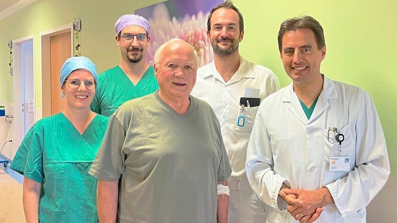 The innovative CSP pacemaker technology was successfully applied to an 82-year-old patient in the cardiac catheterization laboratory at the Wels-Grieskirchen Clinic (from left to right: DGKP Lisa Zauner, BSc, DGKP Edgar Weissböck, the patient, OA Dr. Peter Huber and Prim. Priv.-Doz. Dr. Ronald Binder) (Bild: Klinikum Wels-Griesirchen)