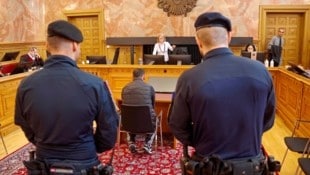 Der Angeklagte sitzt in der Mitte des Schwurgerichtssaales, flankiert von zwei Justizwachebeamten. (Bild: Markus Tschepp)