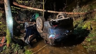 Der Geländewagen landete auf dem Dach im Mirnigbach. Der verletzte Lenker konnte sich aus dem Wrack befreien, aber keinen Notruf absetzen.   (Bild: FF Eberstein)