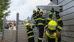 Feuerwehrleute bauen in der Nähe der Karlsbrücke in der tschechischen Hauptstadt Prag eine Hochwasserbarriere auf. (Bild: APA/AFP)