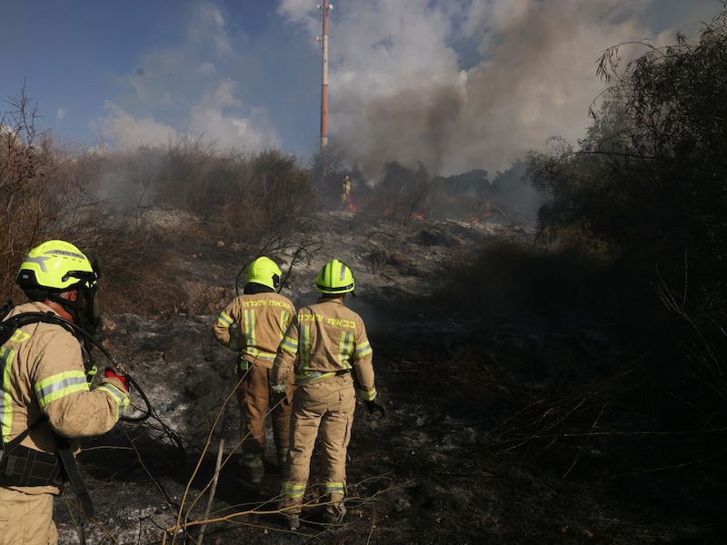 Feuerwehrleute nach dem Angriff in der Nähe der Stadt Lod (Bild: APA Pool/AFP/Menahem KAHANA)