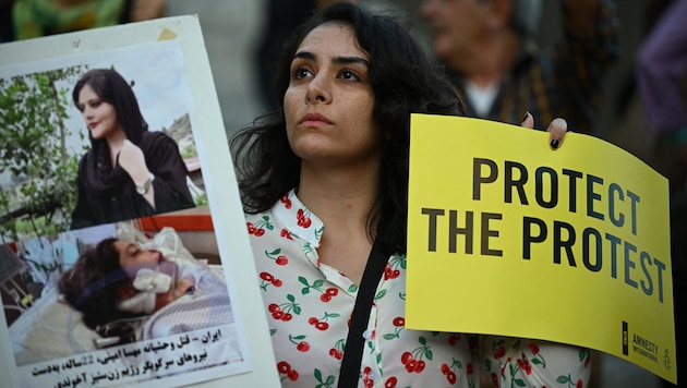 A demonstrator holds up a picture of the Iranian Kurdish woman Jina Mahsa Amini, who was arrested so brutally by moral guards that she died. (Bild: AFP)