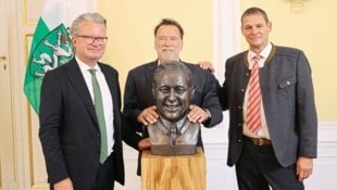 Arnold Schwarzenegger – mit Landeshauptmann Christopher Drexler und Krainer-Sohn Ferdinand – enthüllte die Büste des verstorbenen Landeshauptmanns. (Bild: Jauschowetz Christian/Christian Jauschowetz)