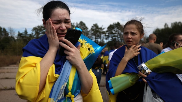 A Ukrainian woman talks to her children on the phone after being released from Russian captivity near the Ukrainian-Belarusian border. (Bild: APA/AFP/Anatolii STEPANOV)