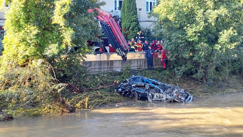 Aufräumarbeiten im halben Land: Im Wienfluss landete ein Auto, in dem glücklicherweise keine Menschen gewesen sein dürften. (Bild: picturedesk.com/APA/ROMAN PAYER)