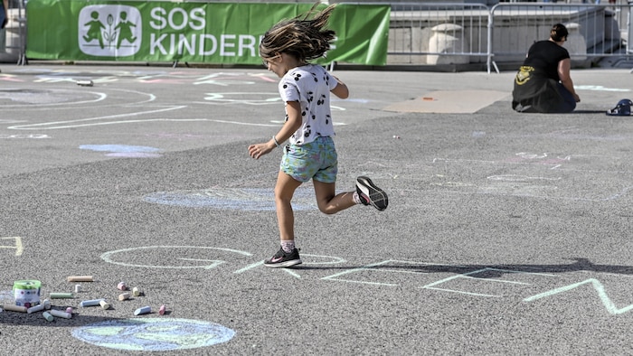 Teilnehmer einer Straßenkreide-Aktion von SOS-Kinderdorf