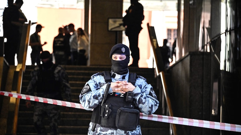 A Russian police officer secures the office building after the fatal shooting at the headquarters of Russia's largest online retailer Wildberries. (Bild: AFP/Alexander Nemenov)