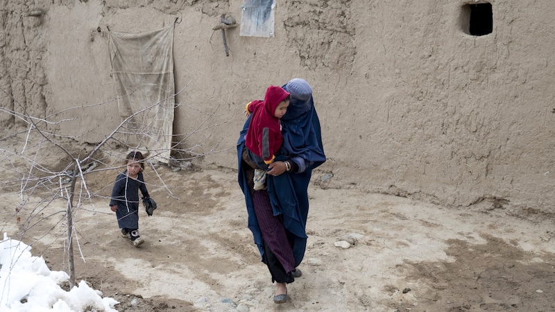 Eine Afghanin mit zwei Kindern – jedes zehnte Kind unter fünf Jahren ist in dem islamischen Staat unterernährt. (Bild: AFP)