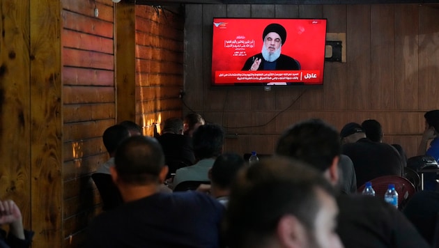 People watch a TV set while Nasrallah gives a speech. (Bild: AP/Hassan Ammar)