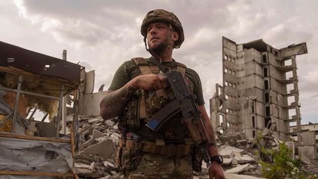 Ukrainian soldier in the midst of destruction (Bild: AP/Evgeniy Maloletka)