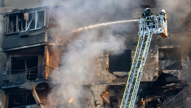 Photos show debris in front of a multi-storey house and a burnt car. (Bild: AP)