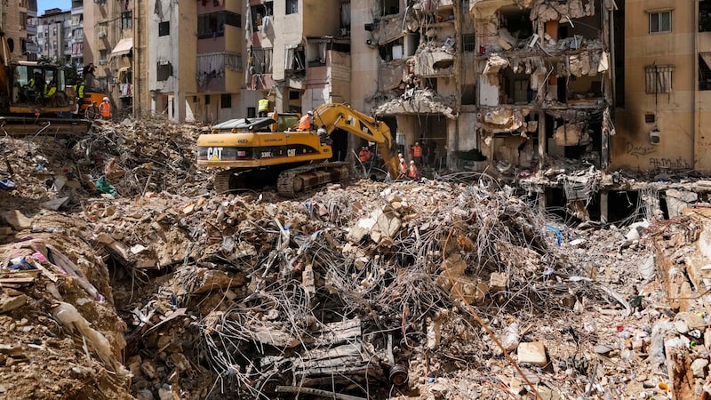 Rettungskräfte durchsuchen die Trümmer auf der Suche nach Vermissten in den südlichen Vororten von Beirut. (Bild: AP ( via APA) Austria Presse Agentur/Hassan Ammar)